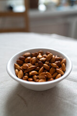 Plate with almonds on a light surface
