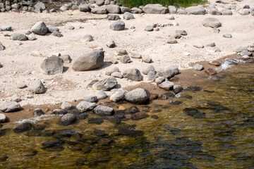 Strand am Wasser mit Steinen