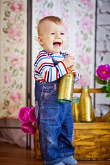 cute little boy standing with a golden bottle in his hands