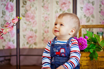 little boy sitting on the floor with flower