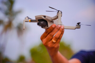 drone copter in hand on sky background. Remote controlled copter with digital camera in the hand. Closeup. New tool for aerial photo and video.