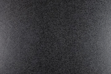 Closeup of black, rough background lit with dim light.