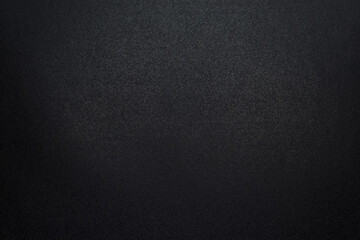 Closeup of black, rough background lit with dim light.