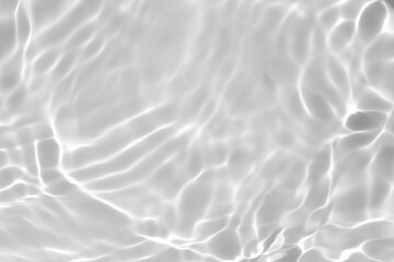 Fototapeta na wymiar Closeup of desaturated transparent clear calm water surface texture with splashes and bubbles. Trendy abstract nature background. White-grey water waves in sunlight