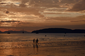 people walking at the beach on beautiful summer sunset