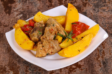 Baked pork meat with potao and tomato