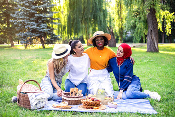 Young multiracial women are on picnic in the park.