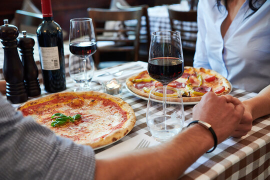 Verliebtes Paar besucht ein Restaurant und h&auml;lt die H&auml;nde und trinkt ein glas wein