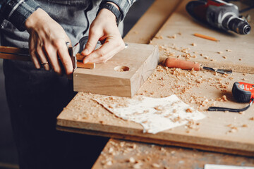 Fototapeta na wymiar A man carves a tree. The carpenter works in a studio. An engineer provides a tree shape