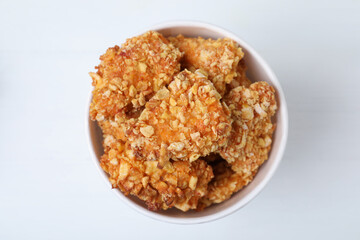 Bucket with yummy nuggets on white wooden table, top view