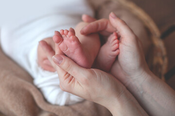 Newborn baby feet in father hands. Family concept. Props for little baby photoshoot. 