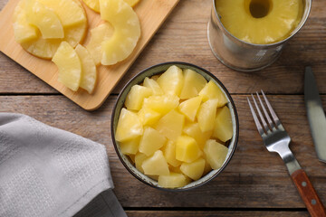 Flat lay composition with canned pineapple on wooden table