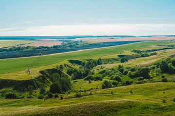 Obraz premium Large panoramic view of the landscape of wheat fields, ears and yellow-green hills, mountain view with lakes