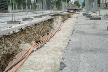 Civil engineering construction ditch with cables and wires in it. The cross section of the dish...