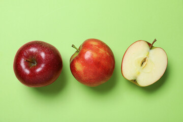 Tasty red apples on green background, flat lay