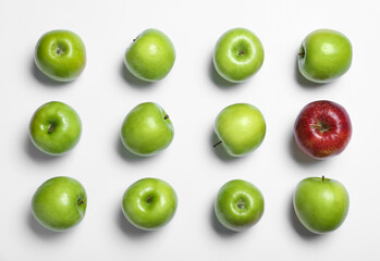 Red apple among green ones on white background, top view