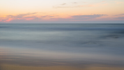 Fototapeta na wymiar Beautiful blurry sunset at the sea on a hot, summer evening.
