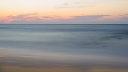 Beautiful blurry sunset at the sea on a hot, summer evening.