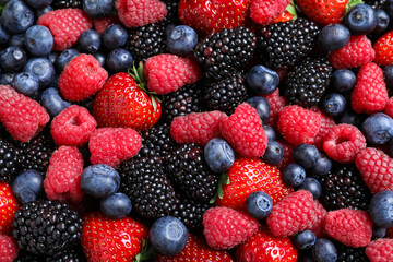 Mix of different ripe tasty berries as background, top view