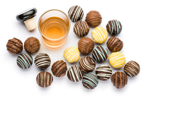 assorted filled chocolates confectionery with liquor glass and copy space on white background