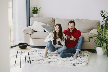 Couple with joysticks. People at home. Pair playing a video games.