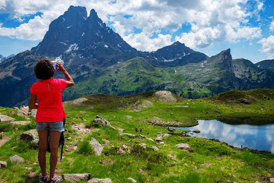 hiking woman drinking water and looking Pic du Midi Ossau in french Pyrenees mountains