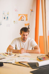 Sad guy Illustrator artist sitting at table in throes of creativity. State of apathy, frustration...