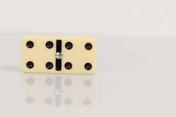 Close up of domino pieces with black dots isolated in white background with reflection