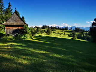 Fototapeta na wymiar Podhale Poland. An old highlander shed in the background of the Tatra Mountains.