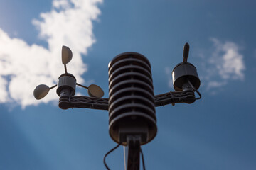 Home weather station on a background of blue sky with the sun behind the clouds. Measurement of...
