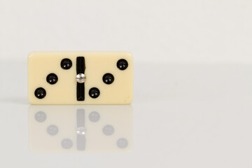 Close up of domino pieces with black dots isolated in white background with reflection