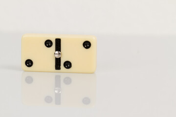 Close up of domino pieces with black dots isolated in white background with reflection