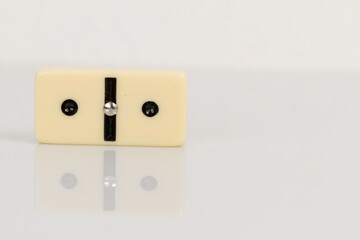 Close up of domino pieces with black dots isolated in white background with reflection