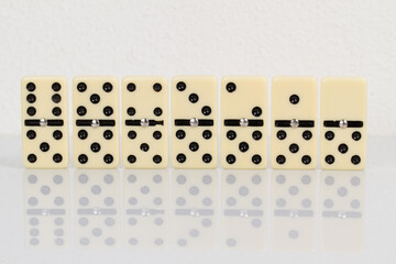 Close up of domino pieces with black dots isolated in white background with reflection