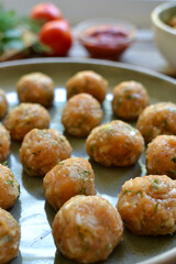 Chicken meatballs recipe. Step by step cooking. Raw chicken meatballs on a gray platter. Close up.