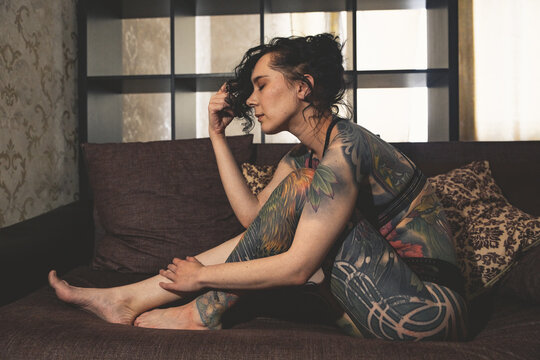 Tatoo Girl On The Sofa In Home