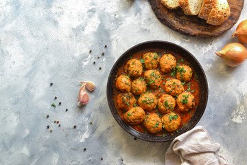 Chicken meatballs in tomato sauce in a pan. Recipe and Step by Step Cooking. Light decorative background. Top view.