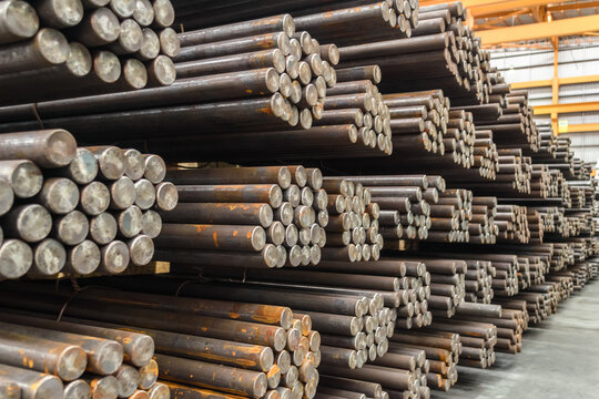 Pack of steel round bar stack in layer inside large distribution warehouse. Steel warehouse logistics operations.