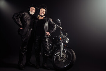 Full length photo of old cool woman man biker couple hug embrace ready ride drive chopper freedom extreme adventure wear leather jacket vintage boots isolated black color background