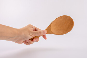 Woman hand with wooden spoon isolated on white background