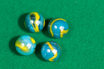 Blue and Yellow Colorful Marble Balls on Green background. Abstract Pattern