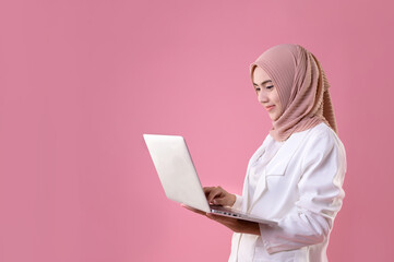 young muslim woman looks in laptop beautiful girl in white suit