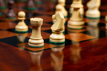 Closeup white king, queen, tower, knight and pawns. Set of chess figures on wooden playing board