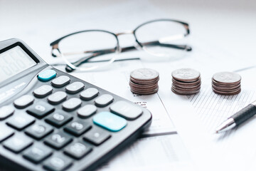 calculator, pen, coins  and glasses on financial documents