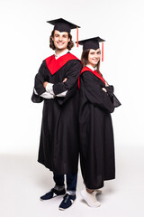Full length portrait of a young couple posing with their diplomas isolated on white background