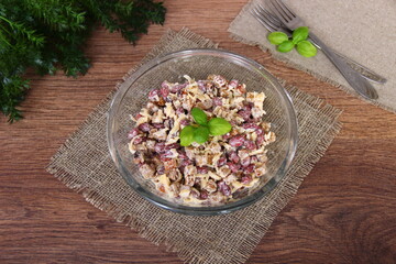 Salad with canned beans and crackers, decorated with Basil, in a glass Cup on a brown napkin, top view