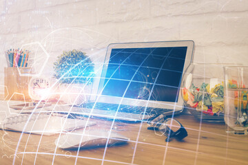 Double exposure of desktop with computer and world map hologram. International data network concept.