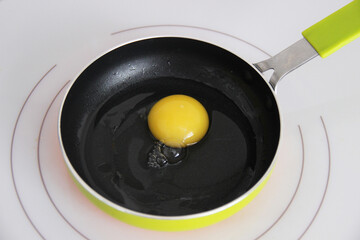 Freshly broken chicken egg in a frying pan for frying fried eggs