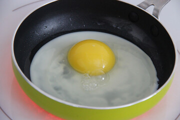 Chicken egg is fried in a frying pan, almost ready