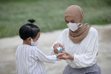 Muslim mother and son using wash hand sanitizer gel pump dispenser, Washing hand with Alcohol Sanitizer, protect the virus and bacterias.